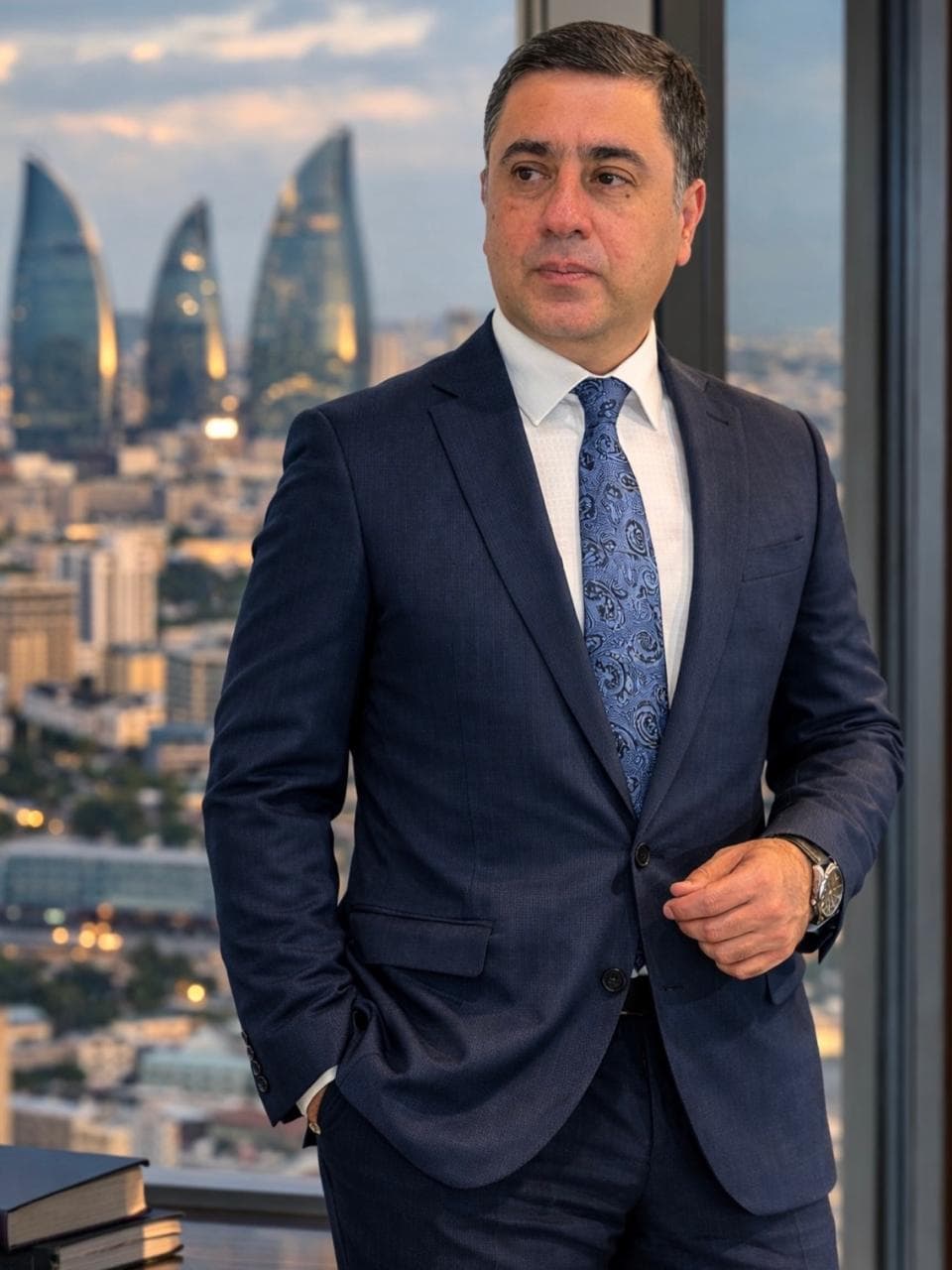 Kamal Əliyev, FinLex Business Advisory-nin təsisçisi, Bakı panoramasına və Alov Qüllələrinə baxan ofis pəncərəsinin önündə